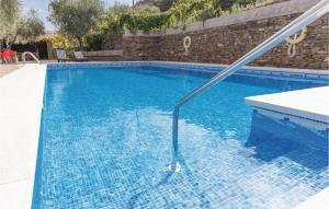 a blue swimming pool with a hose in the water at Stunning Home In Sayalonga With 13 Bedrooms, Wifi And Outdoor Swimming Pool in Sayalonga