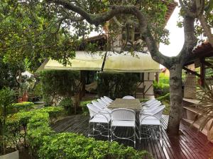 einen Tisch und Stühle auf einer Terrasse im Garten in der Unterkunft Horizonte da serra 1 in Gravatá