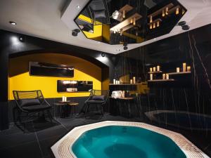 パリにあるLove Hôtel avec nuit insolite au Dandy et Jacuzzi privatiséの黄色い壁の客室内のホットタブ