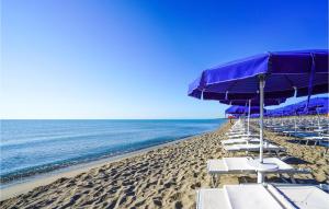 uma praia com cadeiras e guarda-sóis e o oceano em Danaide Trilo em Scanzano