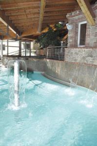 a pool with a water fountain in a swimming pool at Mobil home dans camping in Saillagouse