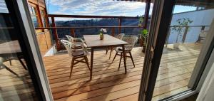 a wooden deck with a table and chairs on a balcony at Weingut & Ferienwohnungen Lenhard in Lang