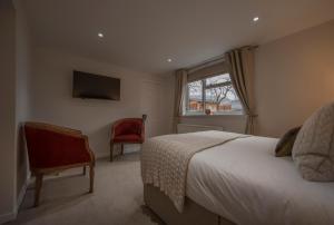 a bedroom with a bed and a window and a chair at Craigmonie Bed & Breakfast in Drumnadrochit