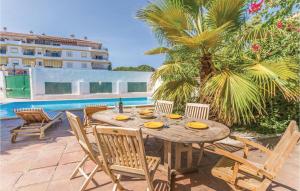 ラ・カラ・デ・ミハスにあるAmazing Home In Mijas Costa With 7 Bedrooms, Wifi And Private Swimming Poolの木製テーブルと椅子付きのパティオ