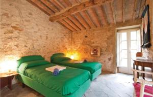 sypialnia z 2 zielonymi łóżkami w pokoju w obiekcie Poggialino w mieście Sasso Pisano
