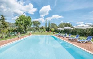 a swimming pool with chairs and umbrellas at Cortilla 3 in Cinigiano