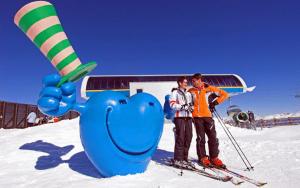 twee mensen op ski's die naast een blauw olifantenbeeld staan bij Hotel-Landgasthof Katschtalerhof in Rennweg