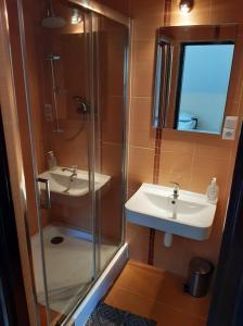 a bathroom with a glass shower and a sink at Restauracja Hotel 4u in Kańczuga