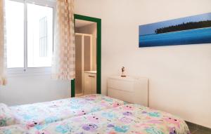 トッサ・デ・マールにあるAmazing Apartment In Tossa De Mar With 2 Bedroomsのベッドルーム1室(ベッド1台付)が備わります。壁には絵画が飾られています。