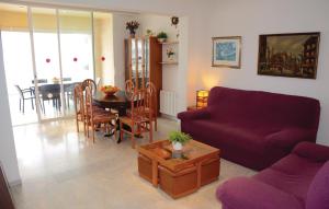 sala de estar con sofá púrpura y mesa en Awesome Apartment In Port De Pollena With Kitchen, en Puerto Pollensa