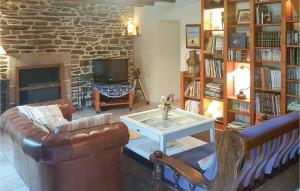 a living room with a leather couch and a fireplace at Awesome Home In Ploneour Lanvern With 3 Bedrooms And Wifi in Plonéour-Lanvern