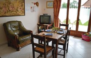 uma sala de estar com uma mesa e cadeiras e uma televisão em Gorgeous Home In Gueschart With Kitchen em Gueschart