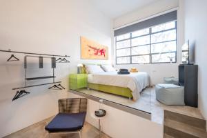 1 dormitorio con 1 cama, 1 silla y TV en Loft 19, en Turín