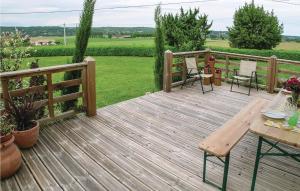 Una terraza de madera con una mesa y sillas. en 2 Bedroom Cozy Home In Saint - Agne, en Saint-Aigne