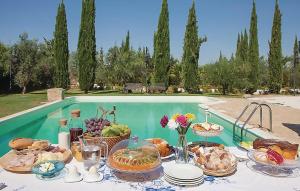 un tavolo con cibo sopra accanto a una piscina di Pet Friendly Home In Chiaramonte Gulfi With Wifi a Chiaramonte Gulfi
