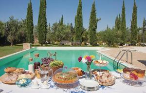 a table with food on it next to a pool at Amazing Home In Chiaramonte Gulfi in Chiaramonte Gulfi +15 photos