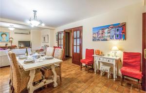 a dining room with a table and red chairs at Lovely Home In Tomares With Kitchen in Tomares