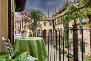 una mesa con un mantel verde en el balcón en Il Terrazzino sul Borgo 1, en Bellagio