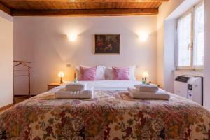 1 dormitorio con 1 cama grande con almohadas rosas en Il Terrazzino sul Borgo 1, en Bellagio