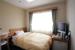 Cama ou camas em um quarto em Fukuchiyama Sun Hotel