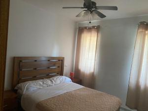 - une chambre avec un lit et un ventilateur de plafond dans l'établissement Mareluna RD, à La Laguna