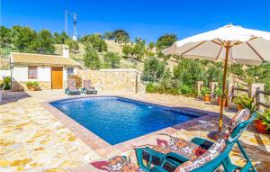 エル・ガストルにあるNice Home In El Gastor With Outdoor Swimming Poolのスイミングプール(椅子、パラソル付)