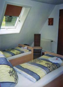 two beds in a small room with a window at Pension Deimel in Hallenberg