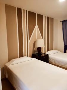 sypialnia z 2 łóżkami i lampką na stole w obiekcie Hostal Alhaja Playa w mieście El Puerto de Santa María