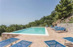 - une piscine avec des chaises longues bleues dans l'établissement Marianna, à Graniti