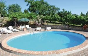 a large swimming pool with chairs and an umbrella at Vigna D in Bevagna