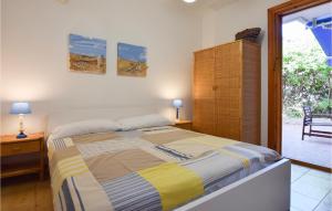 ein Schlafzimmer mit einem Bett und einer Tür zu einer Terrasse in der Unterkunft Stunning Apartment In Marina Di Ragusa in Marina di Ragusa