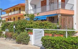 uma cerca branca em frente a um edifício em 3 Bedroom Stunning Apartment In Marina Di Ragusa em Marina di Ragusa