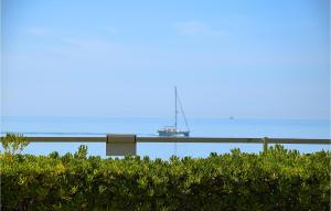 ein Boot liegt im Wasser hinter einer Hecke in der Unterkunft Stunning Apartment In Marina Di Ragusa in Marina di Ragusa