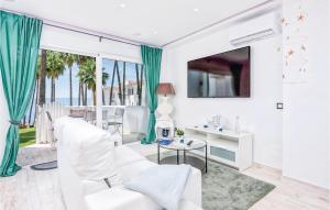 un soggiorno con mobili bianchi e una grande finestra di 2 Bedroom Amazing Apartment In Calahonda a Sitio de Calahonda