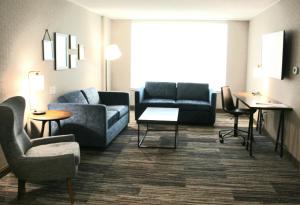a living room filled with furniture and a couch at Sunbridge Hotel & Conference Centre Sarnia in Sarnia