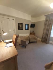 uma sala de estar com duas cadeiras e uma mesa em LLys Aeron Guest House em Aberaeron