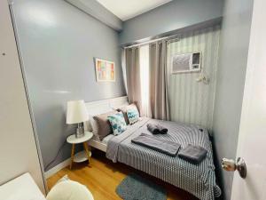 - une petite chambre avec un lit et une fenêtre dans l'établissement 2-Bedroom CK's Corner Staycation Trees Residences, à Manille