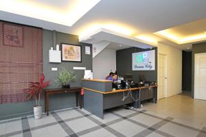 a lobby with a desk with two people sitting at it at Dream City in Kuching