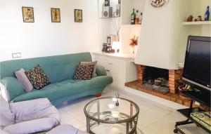 グアルダマル・デル・セグラにあるPet Friendly Apartment In Guardamar Del Segura With Kitchenのリビングルーム(緑のソファ、暖炉付)
