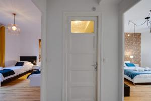 a white door in a bedroom with two beds at Les Capucins - 3 bedroom apartment near the city in Annecy