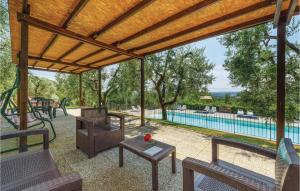 un patio coperto con tavolo, sedie e piscina di Muraiolo a Lamporecchio