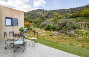eine Terrasse mit Tisch und Stühlen und Blick auf einen Hügel in der Unterkunft Lovely Home In Feliceto With House A Mountain View in Feliceto