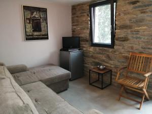 Aegean Deep Blue Andros Ano Aprovato في Apróvaton: غرفة معيشة مع أريكة وتلفزيون