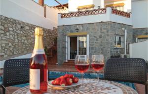 uma garrafa de vinho e dois copos numa mesa em Beautiful Apartment In Fuengirola, Malaga With 2 Bedrooms, Wifi And Outdoor Swimming Pool em Fuengirola