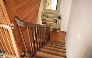 a hallway with a wooden staircase with a book shelf at 2 Bedroom Beautiful Home In Geffosses in Geffosses