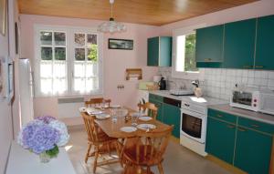 a kitchen with green cabinets and a table with chairs at Nice Home In Pleuven With Wifi in Pleuven +10 photos