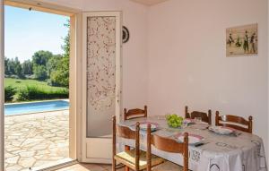 a dining room with a table and a sliding glass door at Lovely Home In Savignac-Ledrier in Payzac