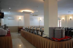 a dining room with chairs and a table with plates at Akar Beach Resort in Port Dickson