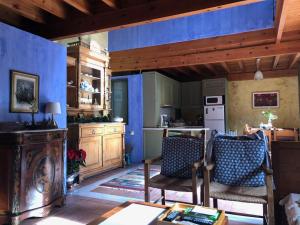 eine Küche mit blauen Wänden, 2 Stühlen und einem Tisch in der Unterkunft Villa Alexandrou in Vamos