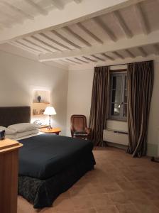 1 dormitorio con 1 cama, 1 silla y 1 ventana en Belvedere Affittacamere, en Città della Pieve